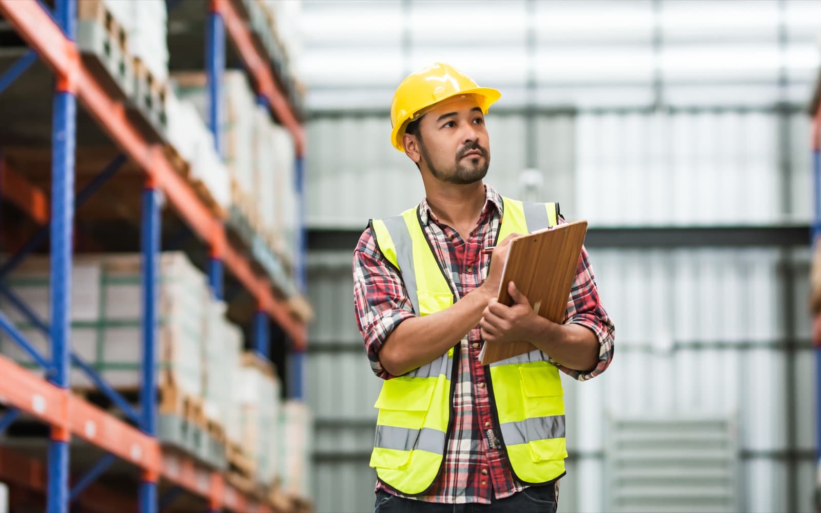 Worker in safety vest and hard hat reviewing a transport safety checklist