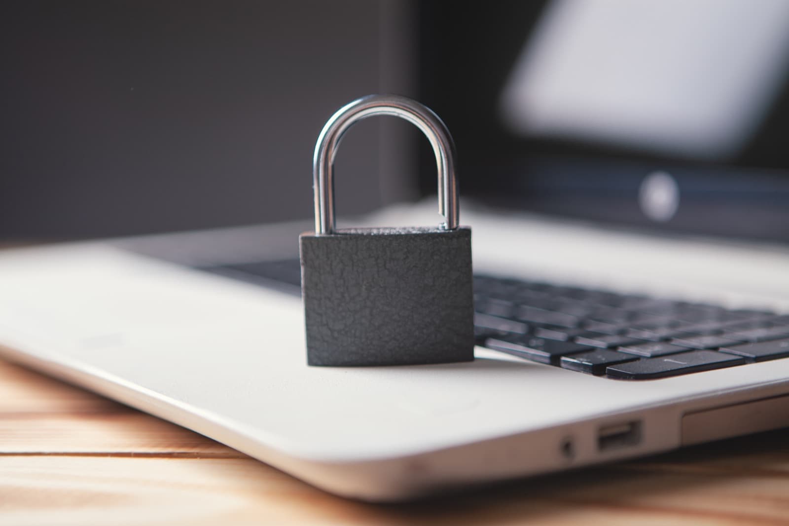 Padlock resting on a laptop keyboard symbolizing PHI data security