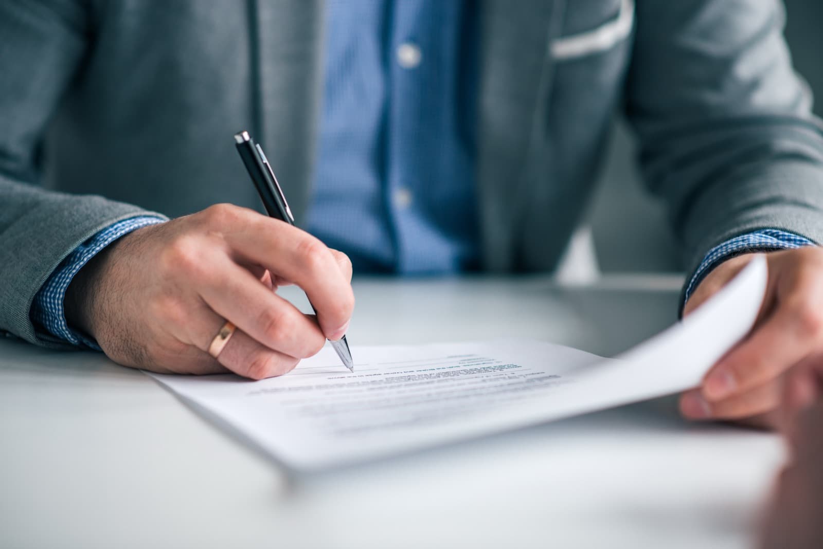 A healthcare administrator reviewing and signing a medical courier service agreement at a desk